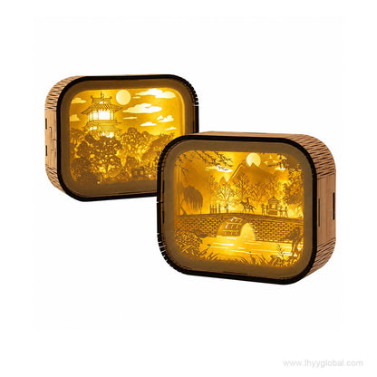 Two custom paper carving LED shadow box lamps with warm illuminated landscape scenes on white background