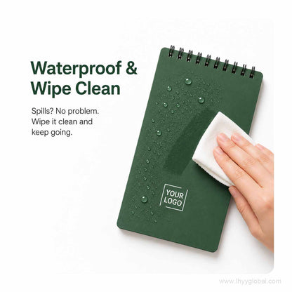 Forest green custom logo pocket spiral notebook with water droplets being wiped clean from the cover.