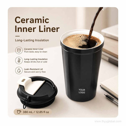 Black ceramic-lined vacuum insulated coffee cup with hot coffee being poured and lid shown beside it.