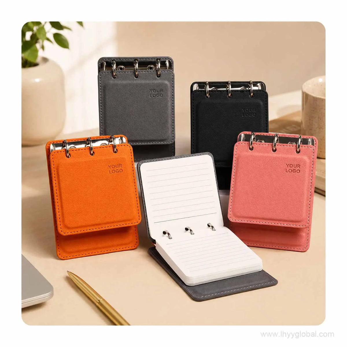 Custom logo pocket loose-leaf notebooks in Orange, Cherry Pink, Mist Gray and Black displayed on an office desk.