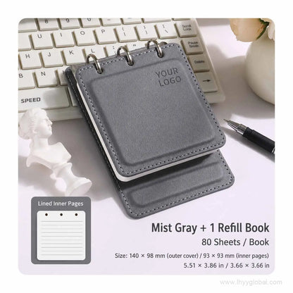 Mist Gray custom logo pocket loose-leaf notebook with 80-sheet lined refill book on an office desk.