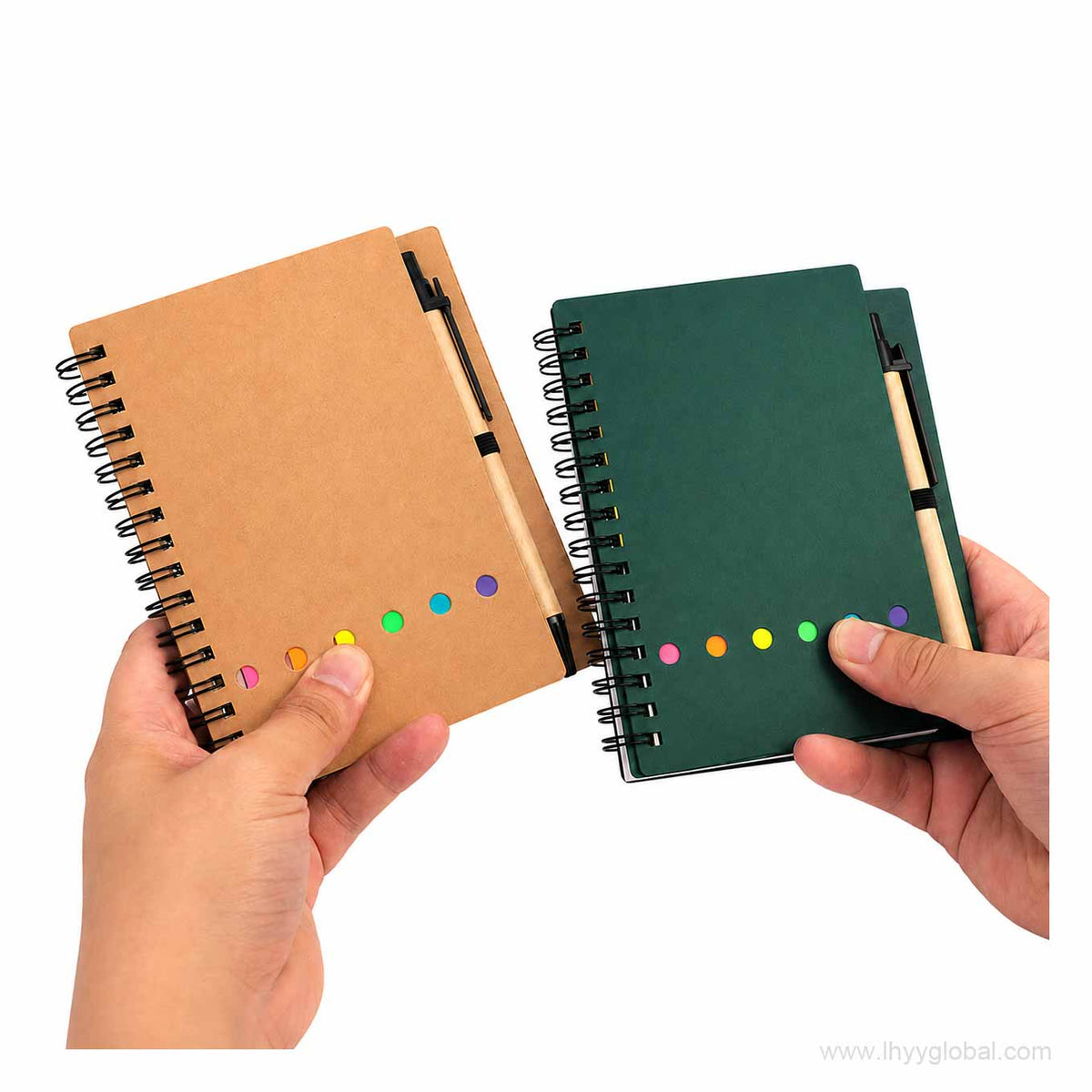 Kraft brown and green A6 spiral notebooks held by hand