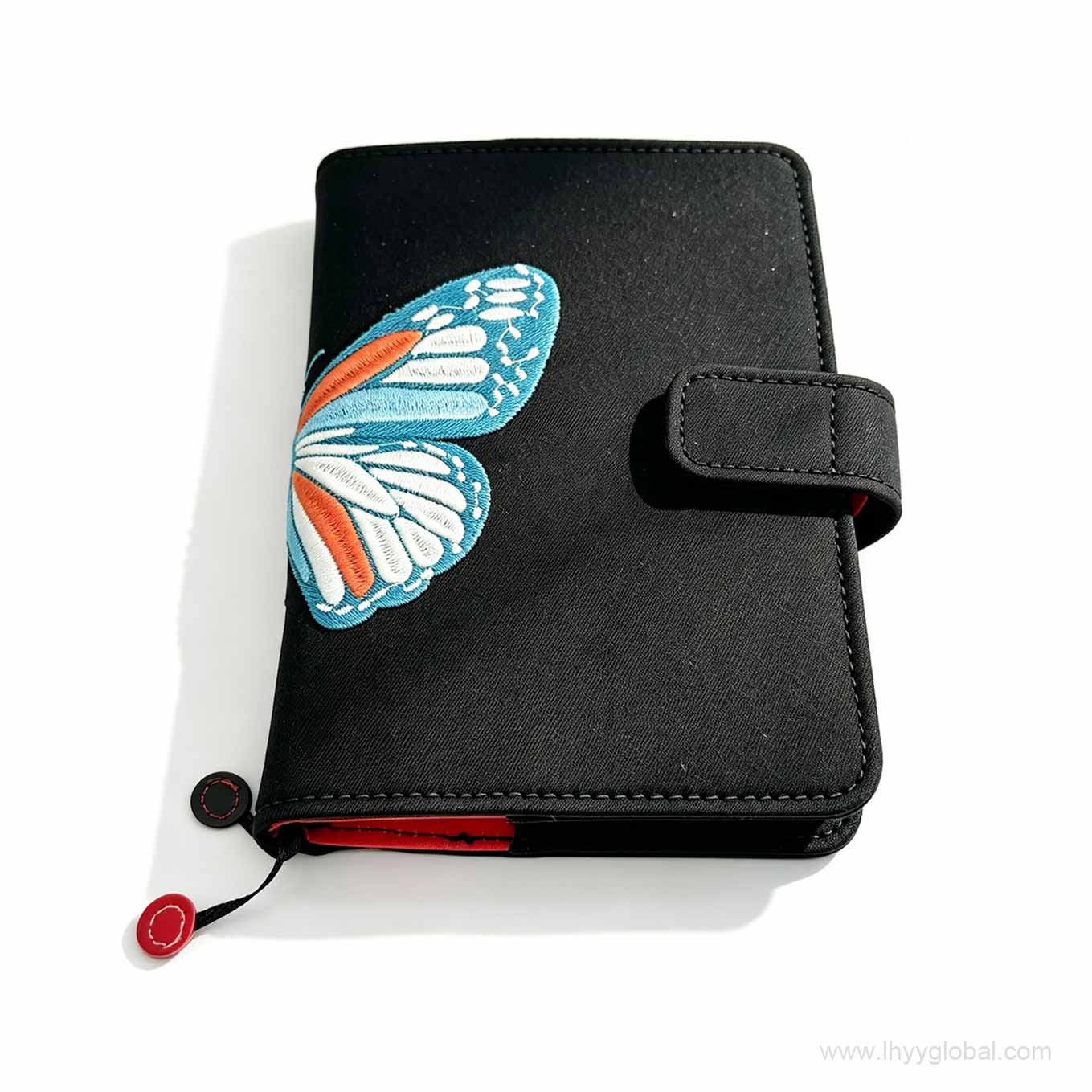 Premium custom embroidered black notebook with colorful butterfly design and magnetic snap closure for biotech corporate gifting.