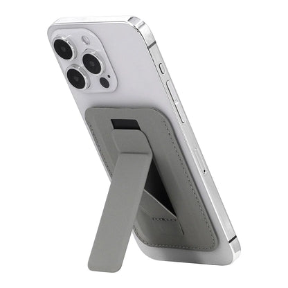 Gray magnetic phone wallet with integrated fold-out stand shown from an angled rear view