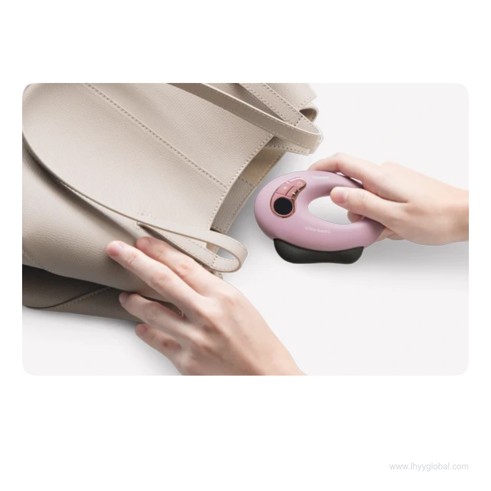 Hands holding a purple OSIM uGlow Guasha massager beside a beige handbag.
