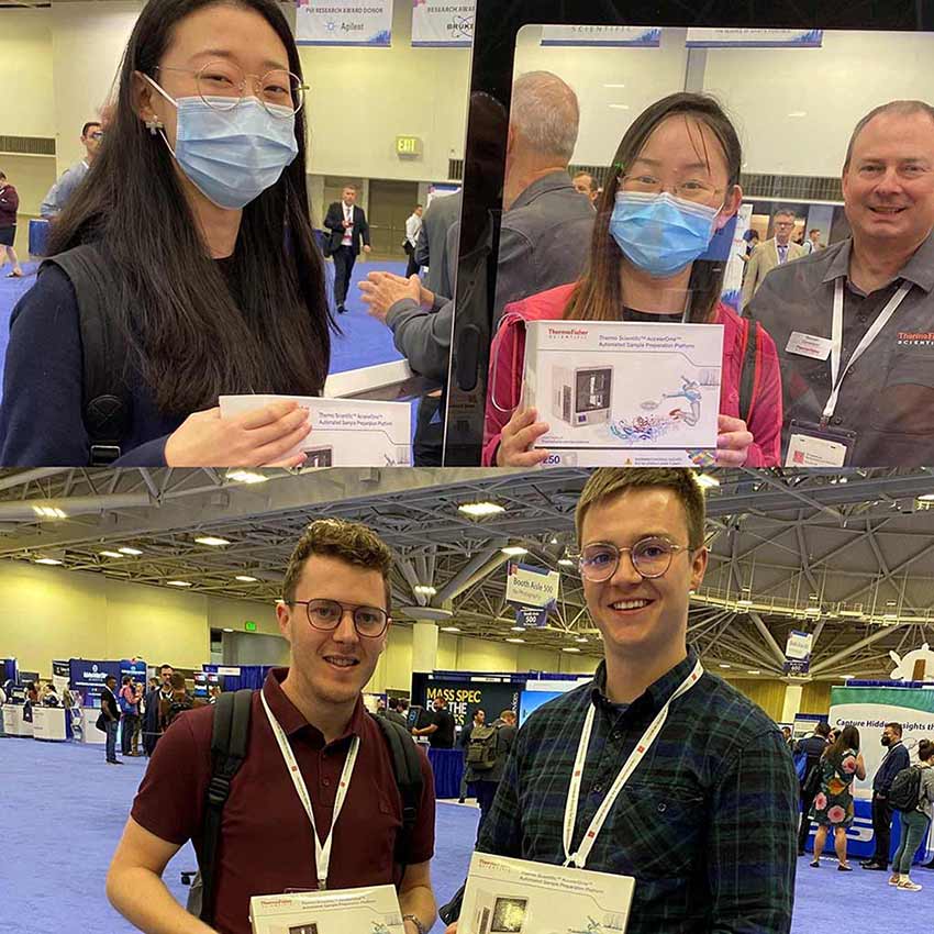 Global marketing team and visitors holding custom Thermo Fisher Scientific AccelerOme automated sample preparation platform brick model kits at a biotechnology exhibition booth.